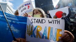 Aksi unjukrasa dilakukan warga Ukraina yang tinggal di Jepang mereka menunjukkan plakat selama demonstrasi mengecam Rusia atas tindakannya di Ukraina, di Kedutaan Rusia di Tokyo, Jepang 23 Februari 2022. [REUTERS/Issei Kato]