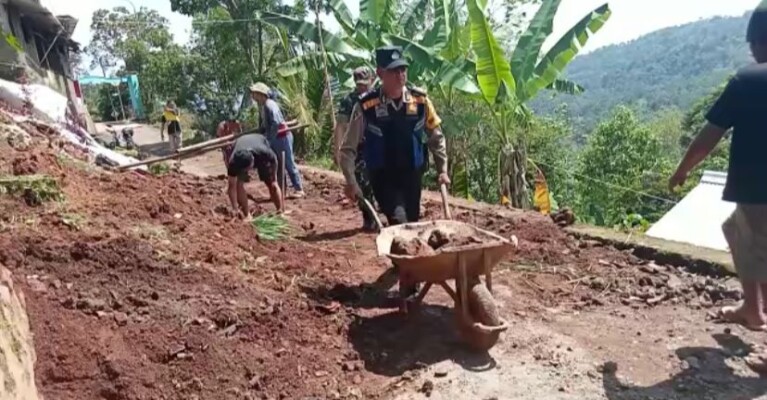 Bersama dengan warga, petugas kepolisian dari Polsek Ganeas Polres Sumedang membersihkan material longsor di Dusun Gorowong, Desa Sukawening, Kecamatan Ganeas, Kabupaten Sumedang. Minggu (23/10/2022).