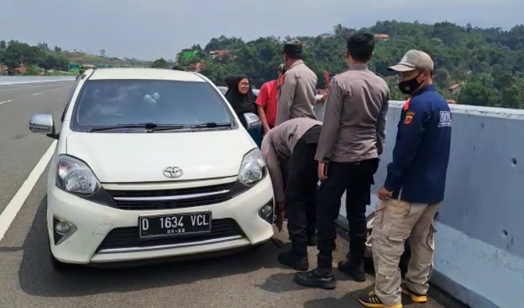 Kasi Dokkes Polres Sumedang, Ipda Gunawan beserta anggota turut membantu mengganti ban mobil seorang pemudik di jalur Tol Cisumdawu. Rabu (19/04/2023).