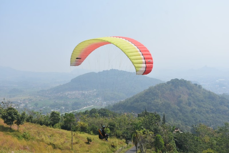 Salah seorang atlet paralayang terbang di langit biru Sumedang pada event babak kualifikasi Pra PON XXI dan Kejuaraan Nasional Cabang Rlah Raga Paralayang di Kabupaten Sumedang.