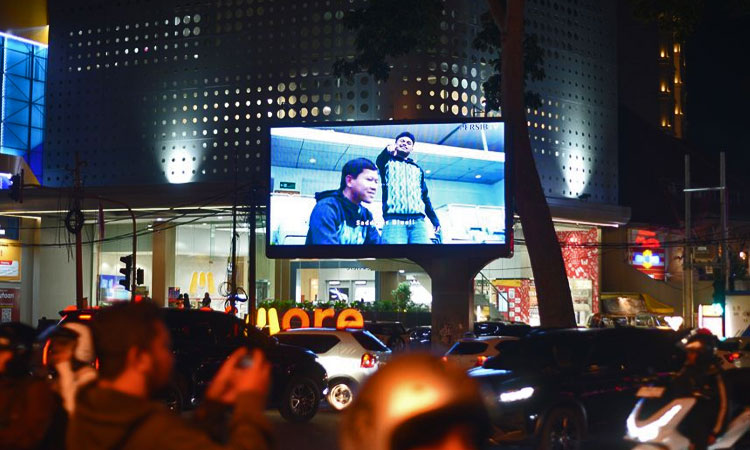 Warga menyaksikan pengumuman perekrutan Saddil Ramdani via videotron di depan Erafone & More Dago, Jalan Ir. H. Juanda No. 52, Kota Bandung.