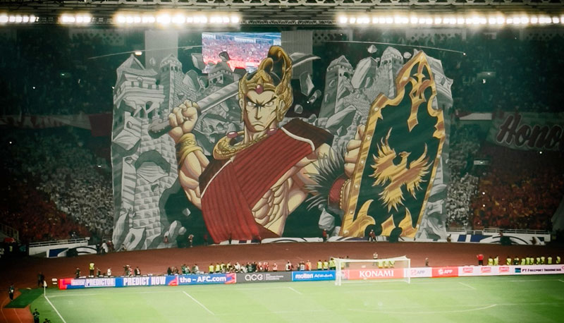 Kelompok suporter La Grande Indonesia yang berada di tribun utara membentangkan tifo raksasa bergambar sosok pendekar wayang.